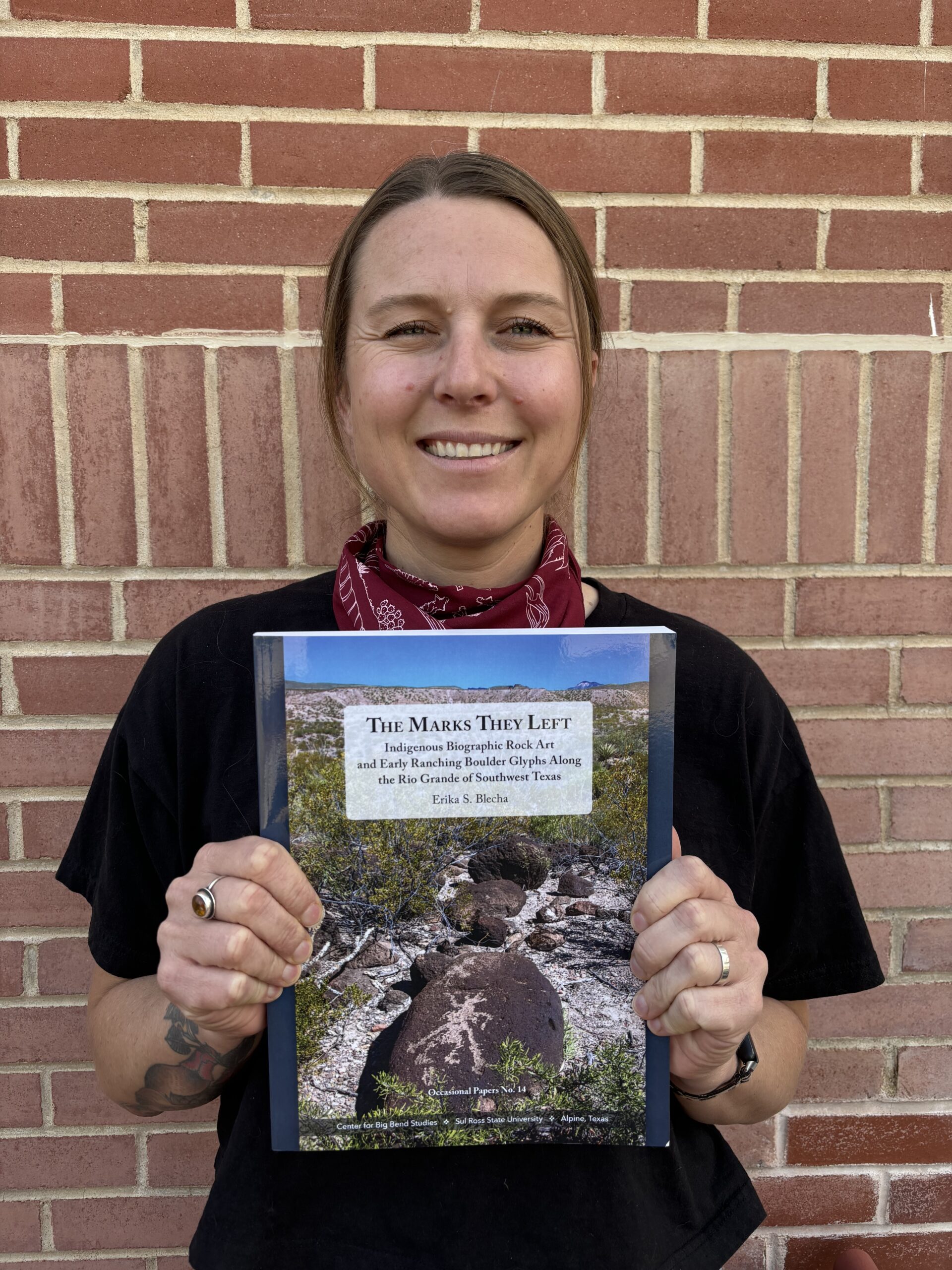 Erika Blecha holding her new publication.